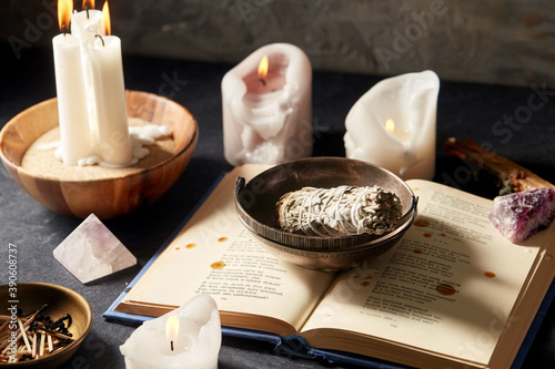Obraz na plátně occult science and supernatural concept - magic book, white sage, burning candle