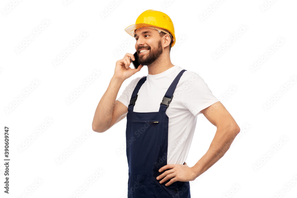 profession, construction and building - happy smiling male worker or builder in yellow helmet and overall calling on smartphone over white background