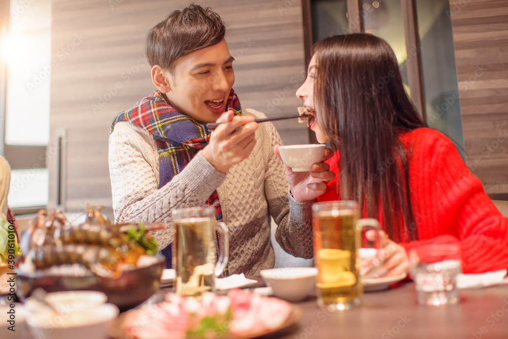 Young man is feeding his girfriend in restaurant Young man is feeding his girfriend in restaurant