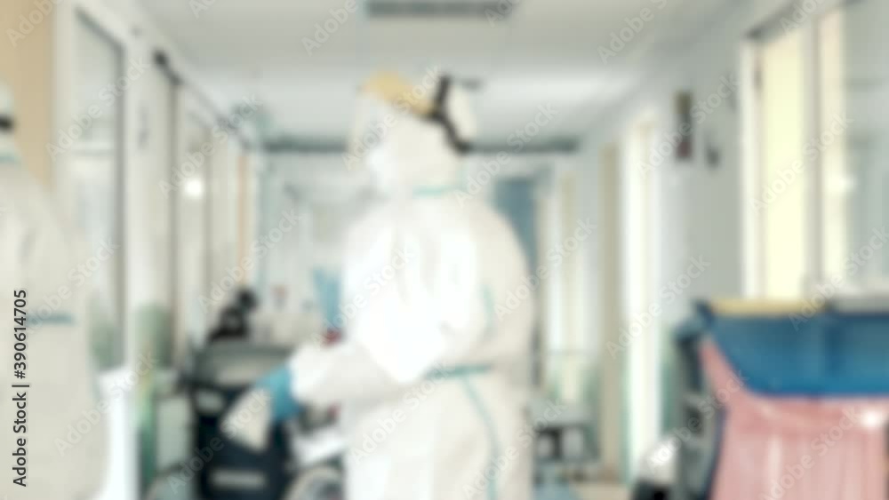 Two nurses working in hospital hallway in full coronavirus COVID protective gear Two nurses working in hospital hallway in full coronavirus COVID protective gear