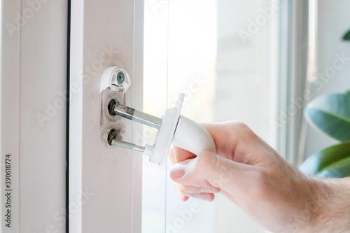 The window handle cracked. The man holds it in his hand, the iron pins are visible