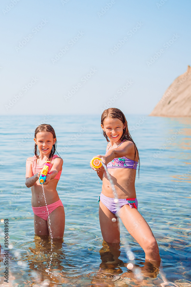 Little happy funny girls have a lot of fun at tropical beach