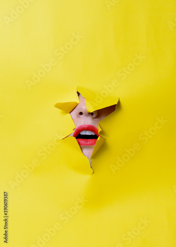 Broken yellow background with a woman's mouth poking out with red lips