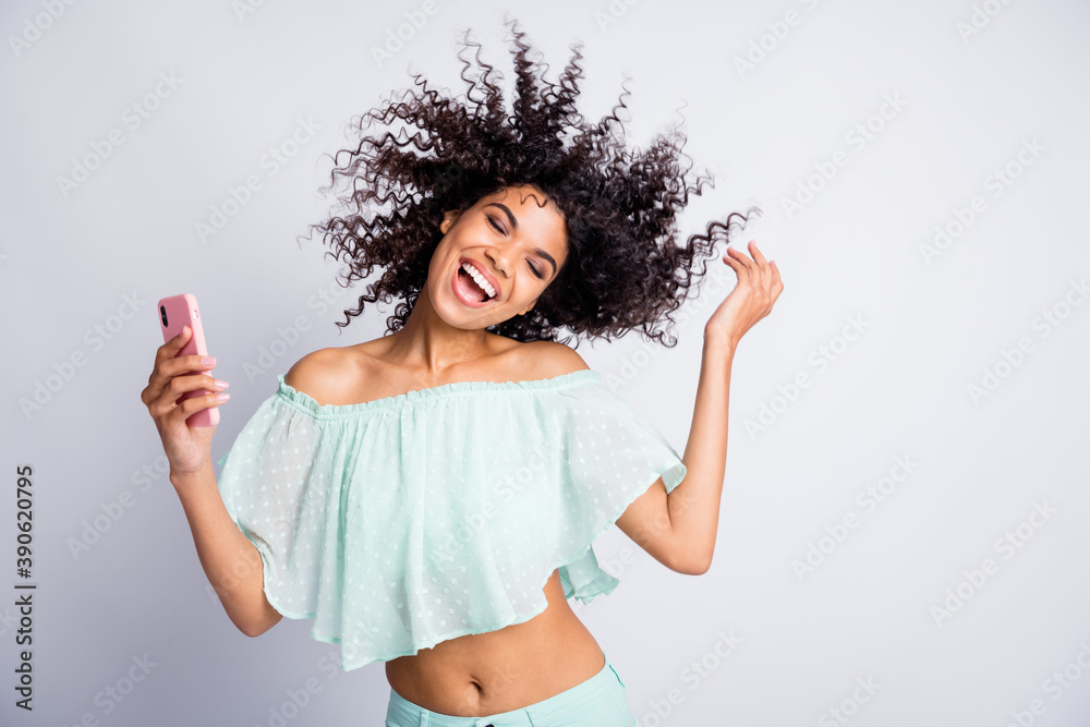 Photo portrait of woman with flying hair holding phone in one hand isolated on white colored background Photo portrait of woman with flying hair holding phone in one hand isolated on white colored background