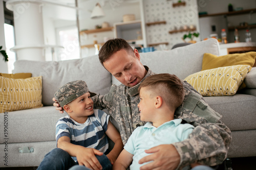 Happy soldier sitting on the floor with his family. Soldier enjoying at home with children..