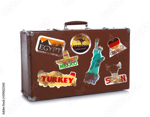 Retro suitcase with travel stickers on white background