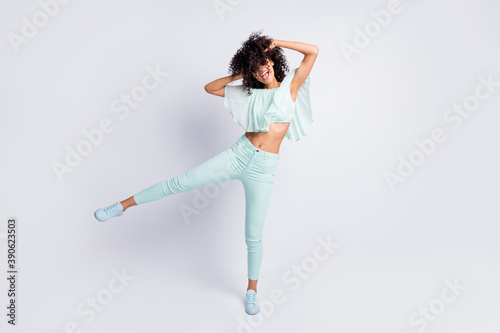 Full length body size photo of carefree playful curly girl in sunglass chilling at party isolated on grey color background
