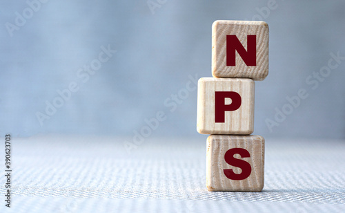 NPS word concept on wooden cubes on gray background photo
