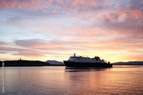 A ship entering Oban harbour in the Scottish highlands during sunset © 13threephotography