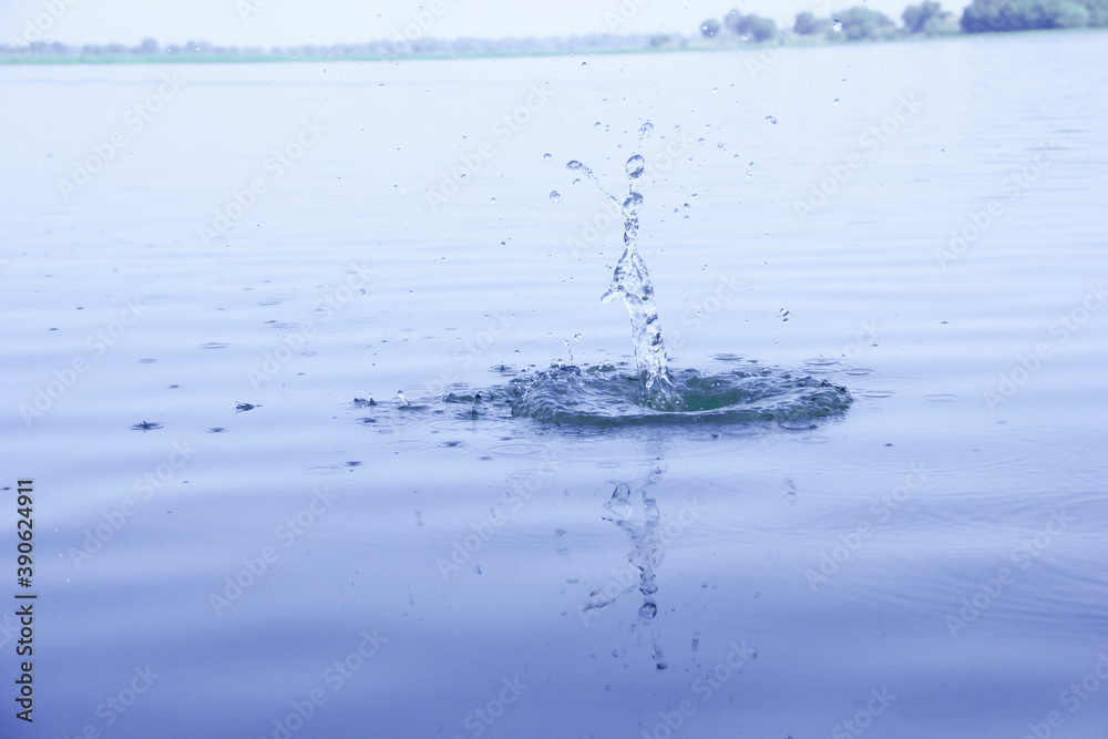 Water splash after throwing stone in water Water splash after throwing stone in water
