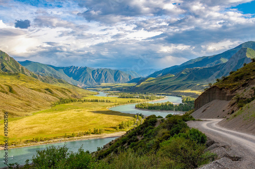 A beautiful valley beyond the pass. The road through the pass in the Altai mountains