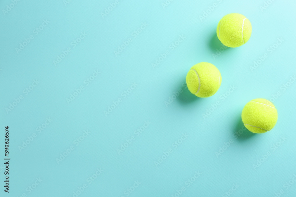 Tennis balls on light blue background, flat lay. Space for text