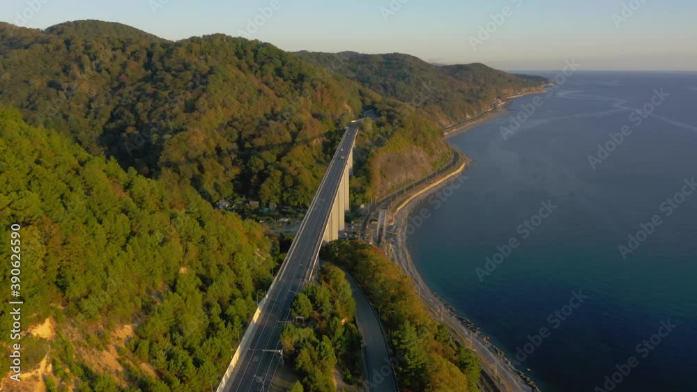 large bridge for motorway across sea, aerial view of drone slide turn, beautiful design of the automotive bridge in sea. Travel. Flying Over Bridge as Cars Pass. Sochi, Russia