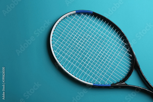 Tennis racket on blue background, top view. Sports equipment © New Africa