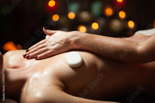 Wallpaper Mural Masseur placing stones on woman's back in spa salon. Girl enjoying body treatment Torontodigital.ca
