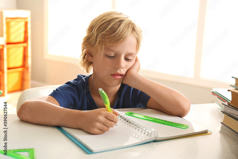 Little boy doing homework at table indoors Little boy doing homework at table indoors