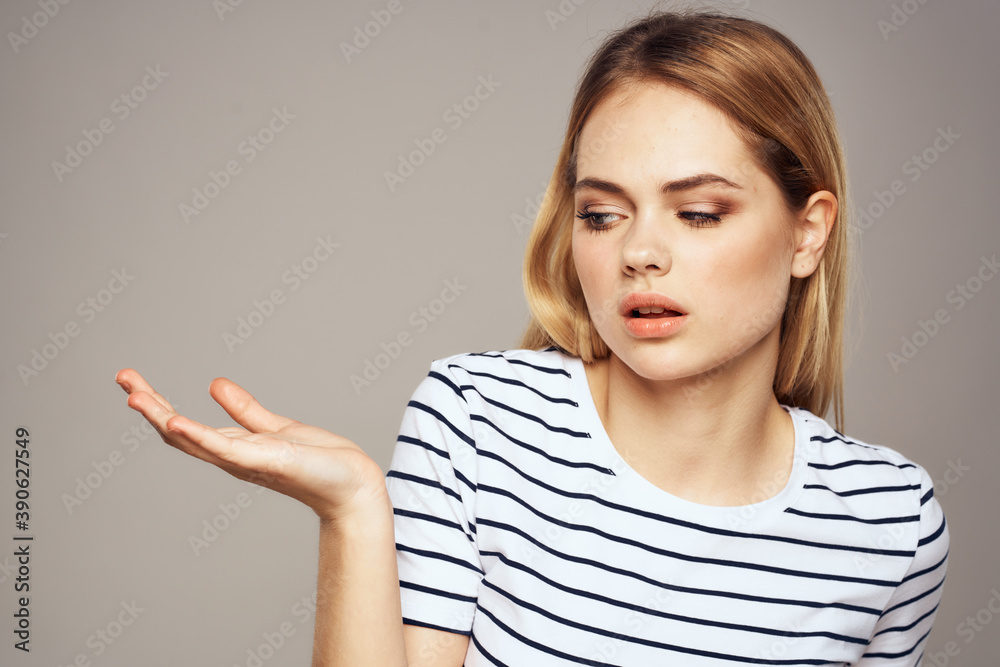 Emotional blonde woman in striped t-shirt lifestyle facial expression close-up Emotional blonde woman in striped t-shirt lifestyle facial expression close-up