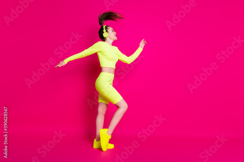 Full length body size profile side view of her she attractive slim cheerful girl listening rock music having fun enjoying dancing isolated bright vivid shine vibrant pink fuchsia color background