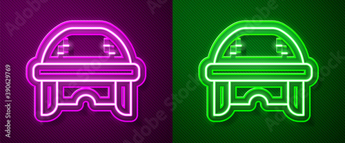 Photography Glowing neon line Hockey helmet icon isolated on purple and green background