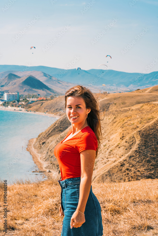 Young woman with long hair on vacation with sea background, paragliders flying in the sky Young woman with long hair on vacation with sea background, paragliders flying in the sky