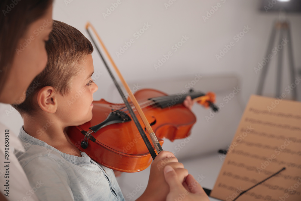 Young woman teaching little boy to play violin indoors, closeup Young woman teaching little boy to play violin indoors, closeup