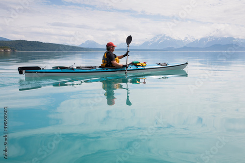 Man sea kayaking calm waters of an inlet in a national park.