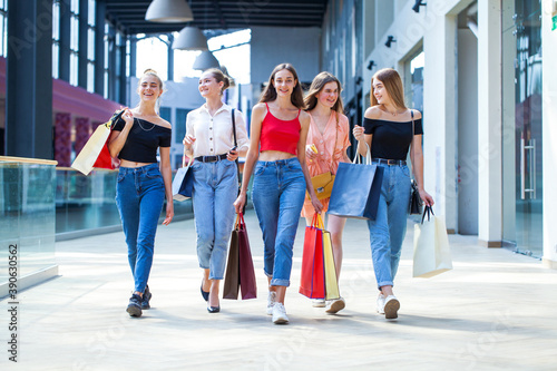 Five happy young women are walking in the mall © Andrey_Arkusha