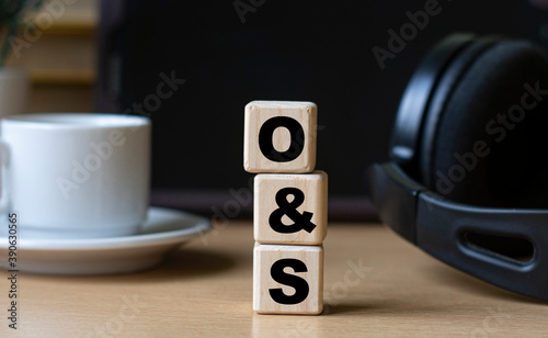 O&S -word on cubes on the background of the tablet, headphones and a white cup photo