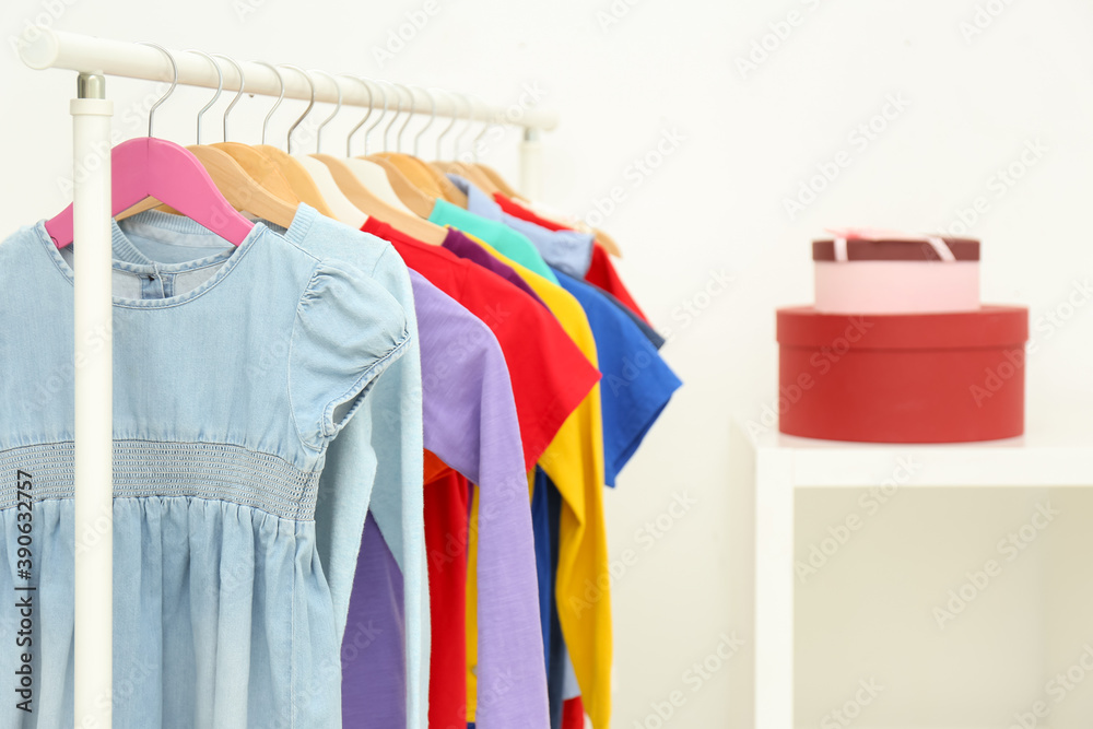 Obraz premium Different child's clothes hanging on rack indoors. Space for text