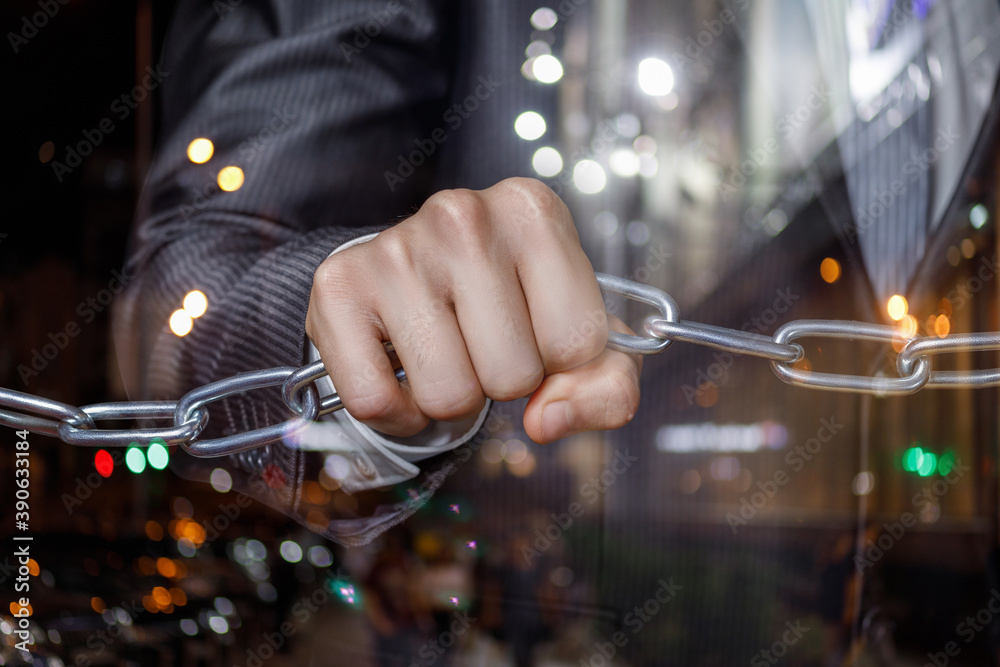 The chain holds the hand of a businessman . The chain holds the hand of a businessman .