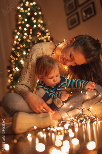 Mother and baby boy playing with Christmas lights