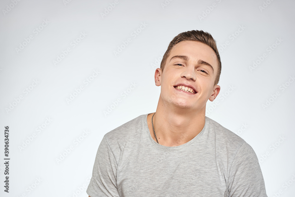 Cheerful emotional man gray t-shirt gesturing with hands studio lifestyle Cheerful emotional man gray t-shirt gesturing with hands studio lifestyle