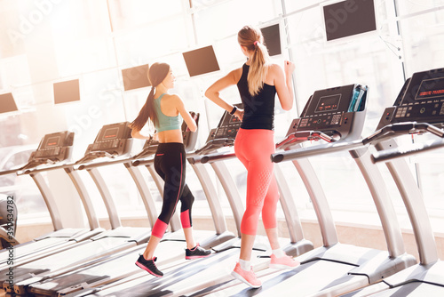 Girls in sportswear running on a treadmill.