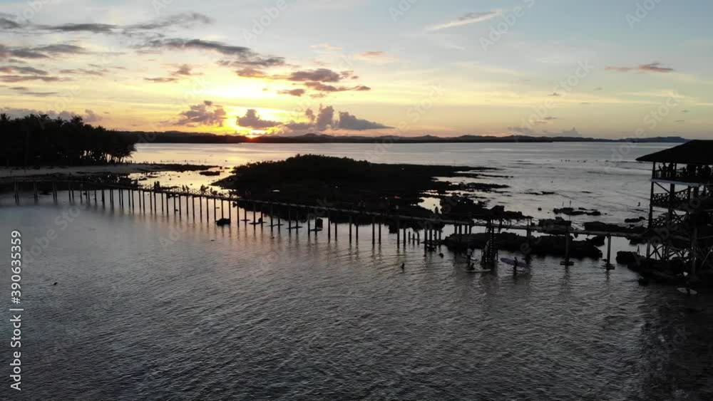 Sideways aerial shot of wooden pier during sunset with ocean landscape in Siargao Philippines. Sideways aerial shot of wooden pier during sunset with ocean landscape in Siargao Philippines.