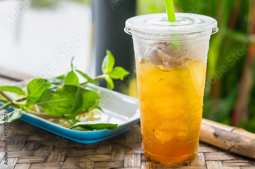 close up of ice cold Longan fruit juice in glass with straw on old table