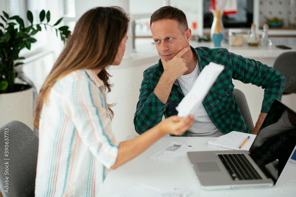 Husband and wife preparing bills to pay. Young couple using laptop.. Husband and wife preparing bills to pay. Young couple using laptop..