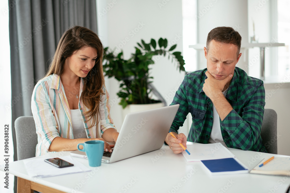 Husband and wife preparing bills to pay. Young couple using laptop.. Husband and wife preparing bills to pay. Young couple using laptop..
