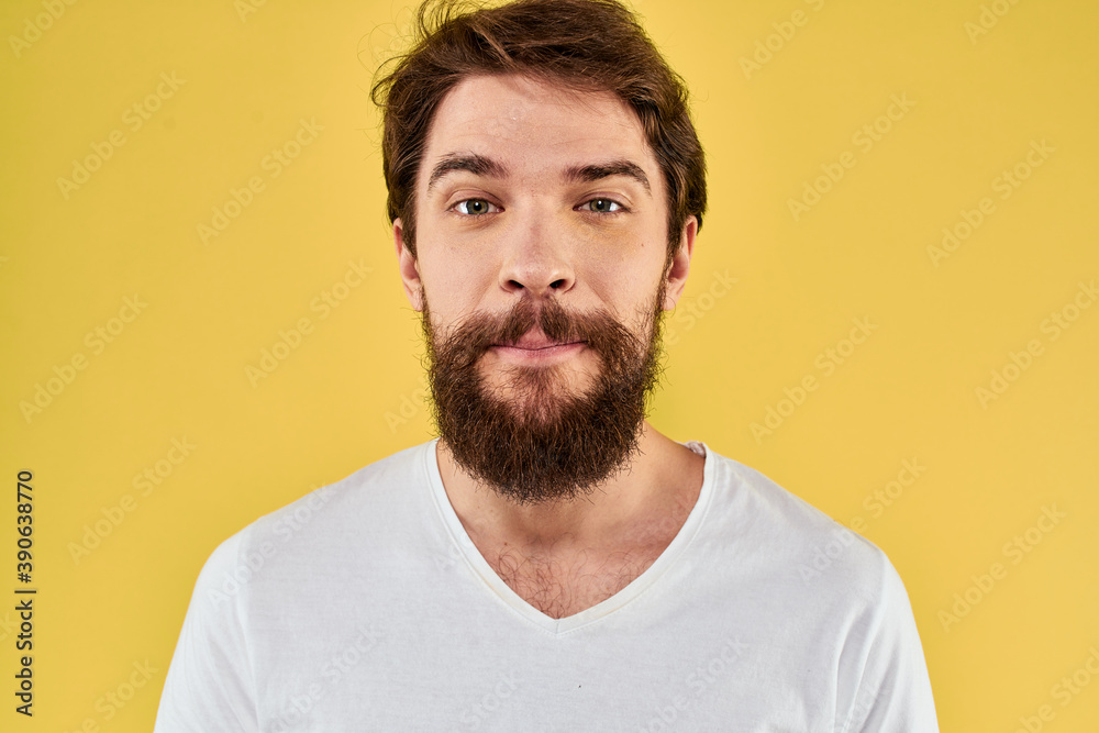 A man in a white t-shirt gestures with his hands lifestyle cropped view yellow background more fun A man in a white t-shirt gestures with his hands lifestyle cropped view yellow background more fun