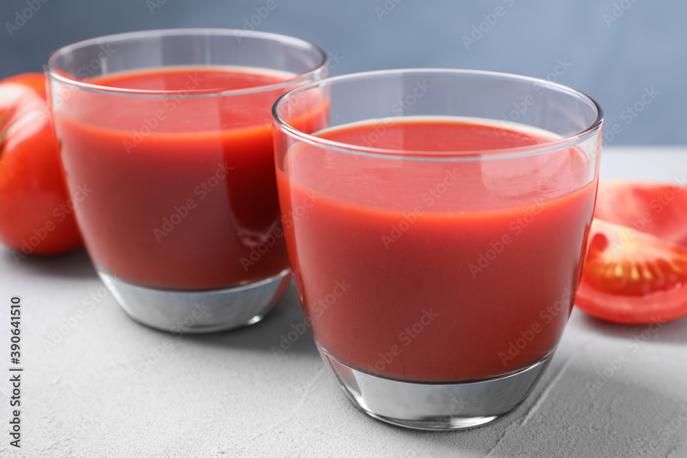Delicious fresh tomato juice on light grey table, closeup Delicious fresh tomato juice on light grey table, closeup