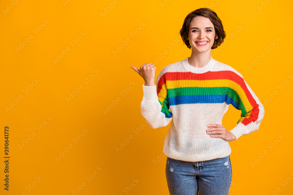 Photo of funky cute brunette hair girl stand pointing empty space wear rainbow sweater denim jeans isolated on bright yellow background Photo of funky cute brunette hair girl stand pointing empty space wear rainbow sweater denim jeans isolated on bright yellow background
