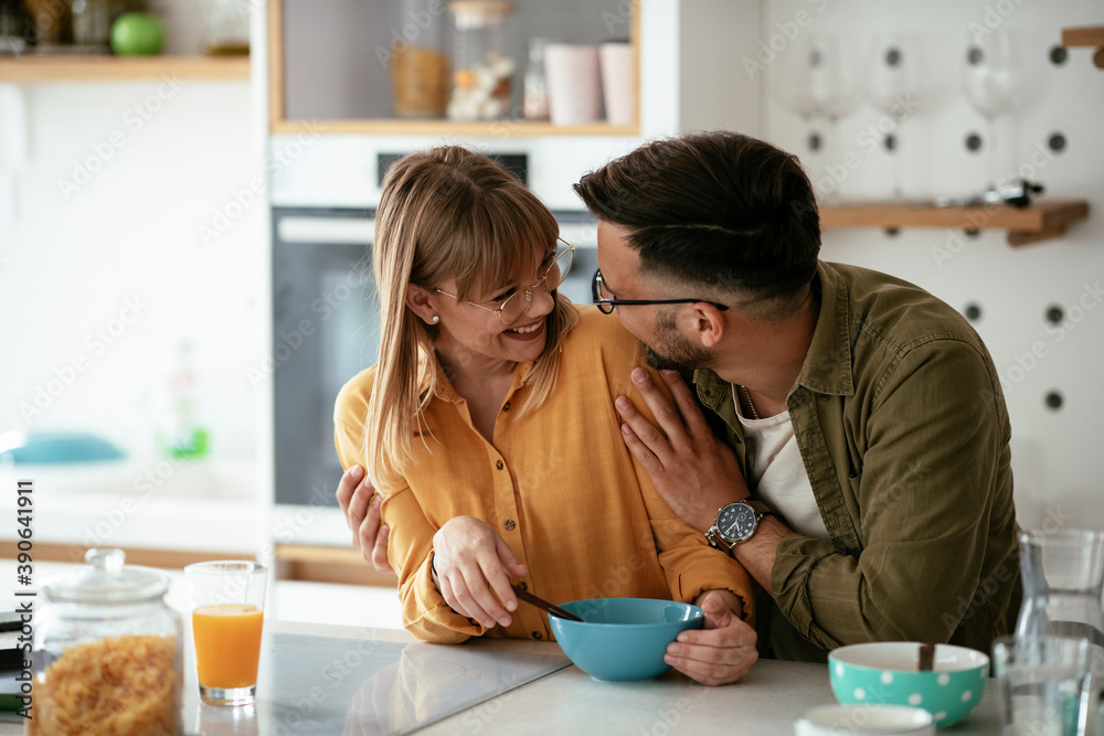 Young couple eating breakfast at home. Loving couple enjoying in the kitchen
