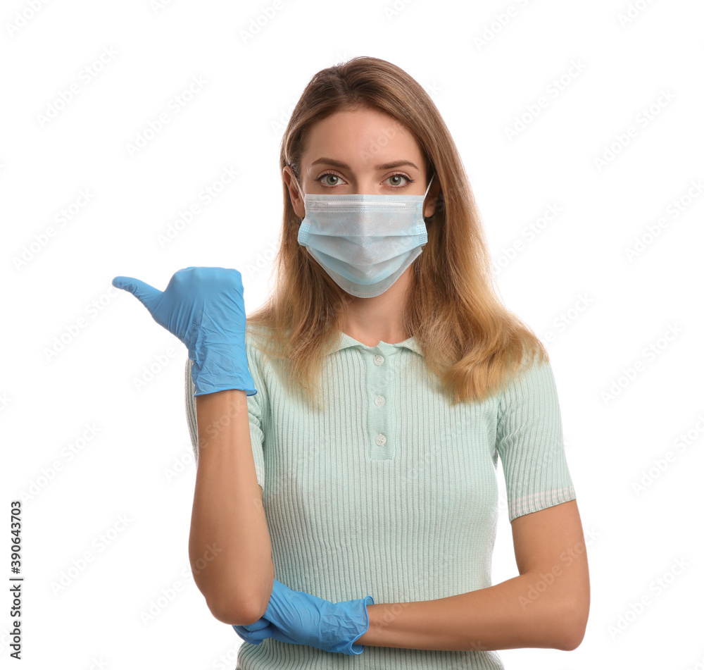 Young woman in medical gloves and protective mask pointing thumb aside on white background Young woman in medical gloves and protective mask pointing thumb aside on white background