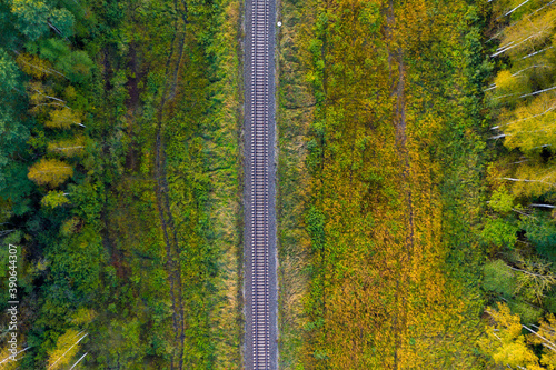 railway track line through autumn forest, view from above