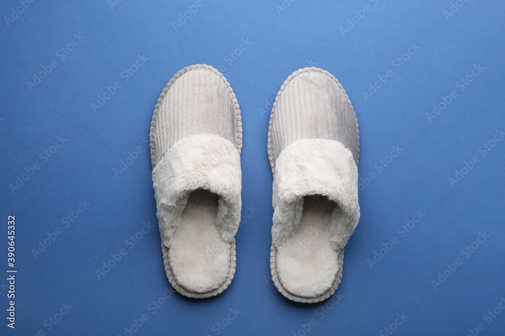 Pair of soft slippers on blue background, flat lay Pair of soft slippers on blue background, flat lay