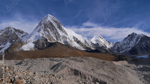 Stunning panorama view of mighty snow-capped mountain Pumori (summit 7,161 m) with Kala Patthar (5,645 m) below and famous Khumbu glacier on challenging Everest Base Camp Trek in the Himalayas, Nepal.