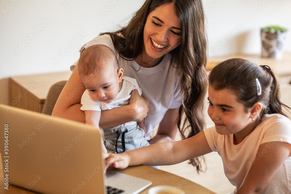 Mother playing with her daughter and baby boy in living room.They using laptop to watch cartoons. Mother playing with her daughter and baby boy in living room.They using laptop to watch cartoons.