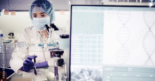 Fe3male doctors in protective workwear studing biohazardous samples. Futuristic laboratory interior. DNA research photo