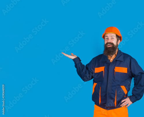 Repairman holds something on hand. Copy space for advertising. Man in protective helmet. Smiling worker in hard hat. Construction worker in hardhat. Repairman.