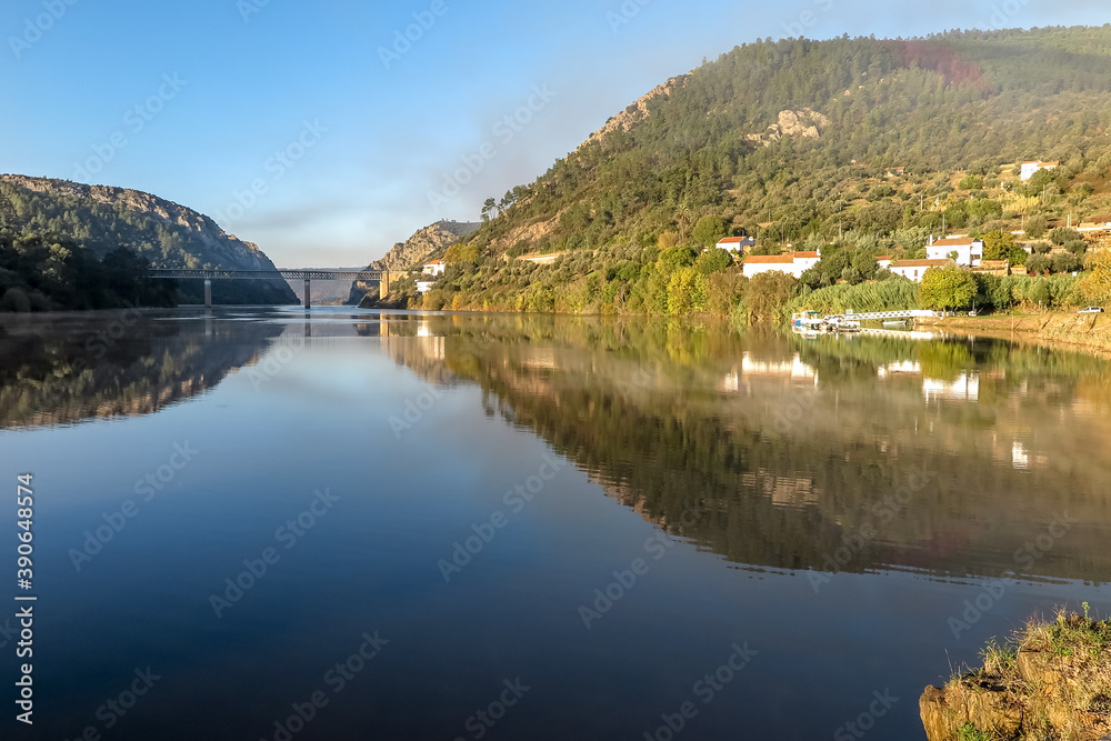 Small village on the Tagus river, with the natural monument of Portas do Rodao in the background, under the morning sun, Vila Velha de Ródão city, Castelo Branco district, Centro region, Portugal