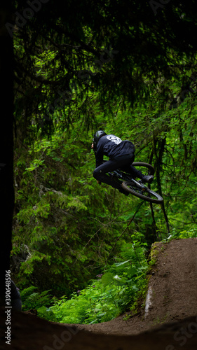 Downhill MTB jumb in the green forest of morgin in switzerland. photo